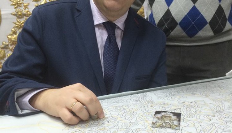 El Presidente de la Hermandad Mariz procede a dar la primera puntada del nuevo termo de la Virgen