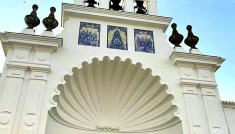 La puerta del Santuario adornada con una foto de la Virgen del Rocío y las medallas de las filiales